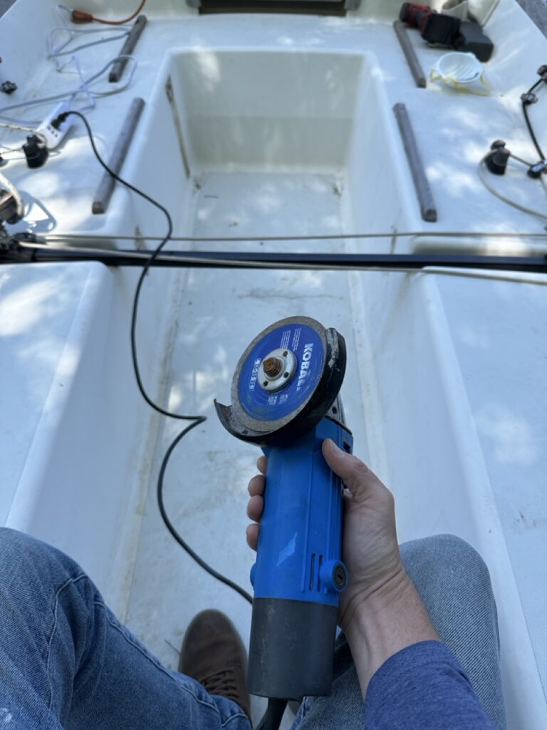 Angle grinder in hand, beginning the cut into the cockpit sole