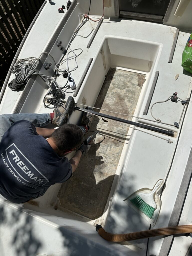 Bent over the cockpit working on the exposed bottom skin